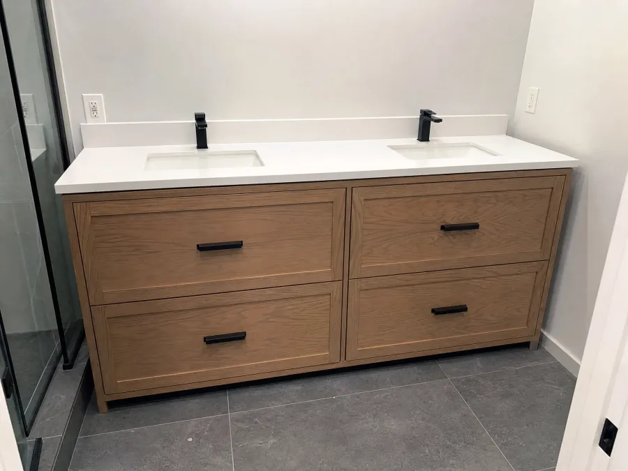 Double-sink white oak bathroom vanity with a white countertop and matte black pulls, by Desert Forge Cabinets