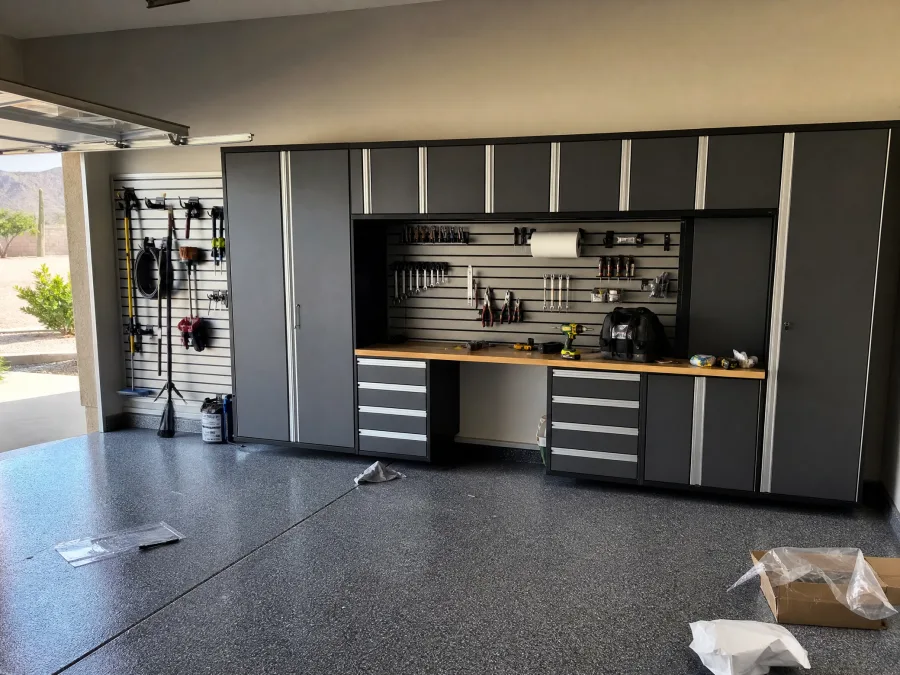 Charcoal garage cabinet system with a slat wall and butcher-block workbench, by Desert Forge Cabinets