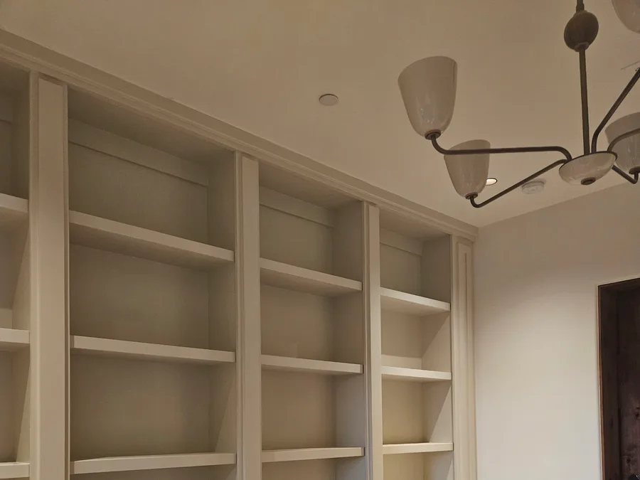 Floor-to-ceiling built-in bookcase with base cabinets by Desert Forge Cabinets